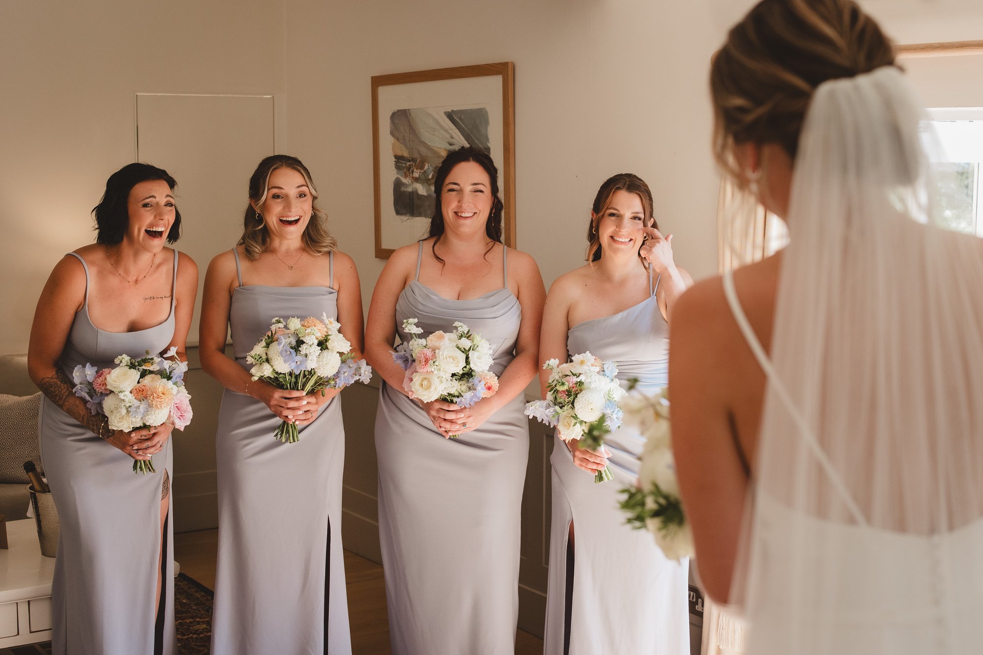 Bridesmaids reacting emotionally to seeing the bride for the first time