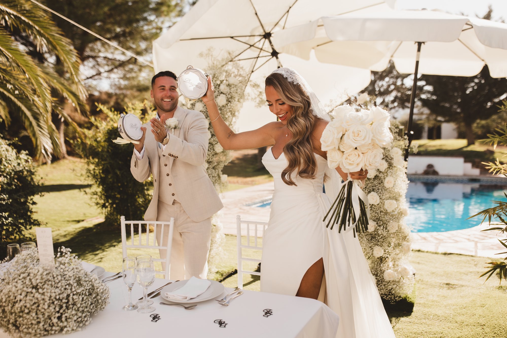 Bride and groom celebrating with personalised tambourines at a destination wedding by the pool